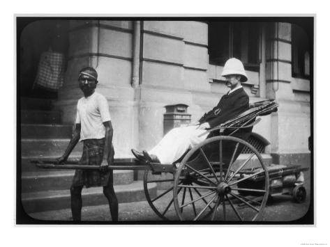 man-wearing-a-pith-helmet-being-transported-by-rickshaw-probably-in-india.jpg