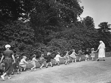 Los niños evacuados de Londres a pie con los cuidadores lo largo de una carretera de primera calidad de impresión fotográfica País