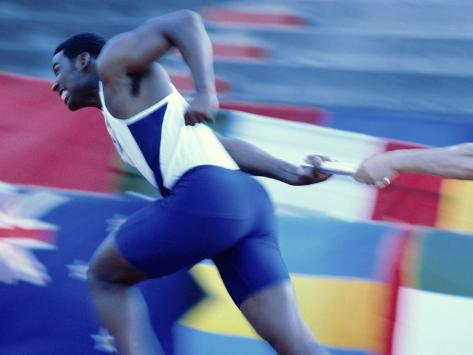 side-profile-of-runners-passing-a-baton-in-a-relay-race.jpg