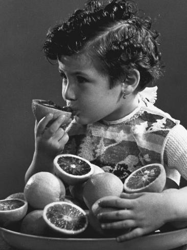 Little Girl Sucking an Orange Photographic Print Don't see what you like