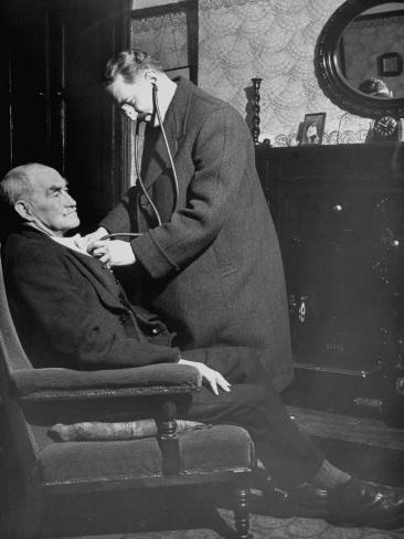 Doctor Making a House Call to an Ill Elderly Man, Listening to the Rhythm of His Heart Premium Photographic Print