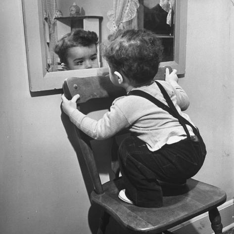 little-boy-standing-on-chair-to-see-face