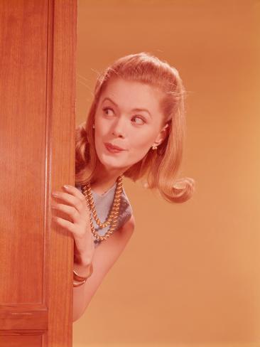 h-armstrong-roberts-young-woman-playfully-peeking-around-door.jpg