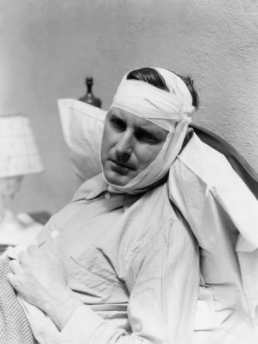 h-armstrong-roberts-man-in-bed-with-bandage-around-head-and-chin-looks-in-pain.jpg