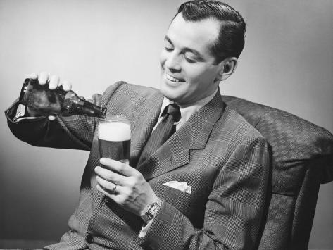 george-marks-elegant-man-pouring-beer-from-bottle-into-glass.jpg