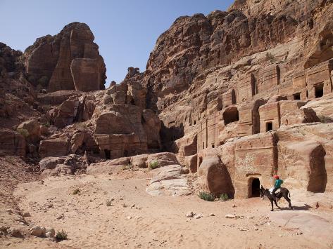 Child Riding a Donkey in Front of Cave Dwellings in Petra, UNESCO World Heritage Site, Jordan, Midd Photographic Print