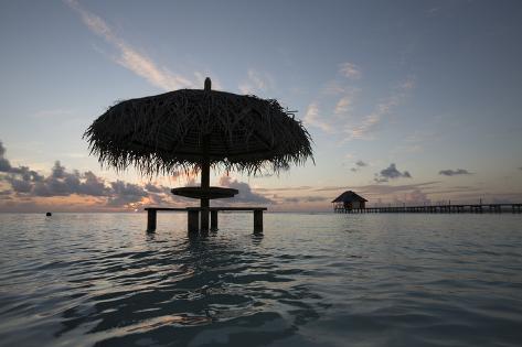 Picnic Table with a Thatched Roof in the Ocean Photographic Print