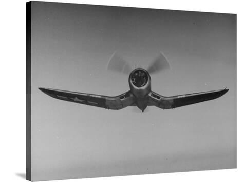 An F4u Fighter Plane Flying Through The Air