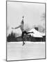 1920s 1930s MAN ICE SKATING ON OUTDOOR ICE RINK DOING AN ARABESQUE JUMPING-Panoramic Images-Mounted Photographic Print