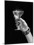 1930s 1940s 1950s WOMAN HAND ORNATE METAL BRACELET HOLDING UP NEW YEAR TOAST GLASS OF CHAMPAGNE...-Panoramic Images-Mounted Photographic Print