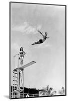 1930s 1940s SHAPELY WOMAN WATCHING MAN SWAN DIVE OFF HIGH DIVING BOARD-H. Armstrong Roberts-Mounted Photographic Print