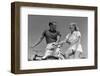 1930s 1940s SMILING BLONDE COUPLE ON BIKES LOOKING AT ONE ANOTHER-H. Armstrong Roberts-Framed Photographic Print