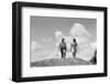 1930s COUPLE MAN WOMAN GOLFERS WALKING TOGETHER OVER CREST OF HILL CARRYING CLUBS-H. Armstrong Roberts-Framed Photographic Print