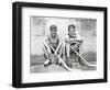1930s TWO SMILING BOYS STREET HOCKEY PLAYERS SITTING ON CURB WEARING METAL ROLLER SKATES HOLDING...-Panoramic Images-Framed Photographic Print