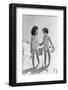 1930s TWO SMILING GIRLS SISTERS FRIENDS HOLDING HANDS AND SAND PAIL AND SHOVEL WALKING ON SAND DUNE-H. Armstrong Roberts-Framed Photographic Print