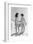 1930s TWO SMILING GIRLS SISTERS FRIENDS HOLDING HANDS AND SAND PAIL AND SHOVEL WALKING ON SAND DUNE-H. Armstrong Roberts-Framed Photographic Print