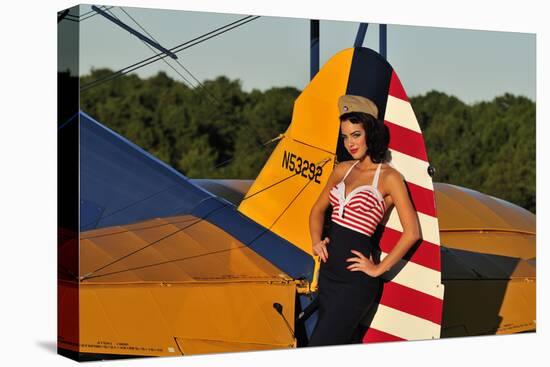 1940's Style Pin-Up Girl Leaning on the Tail Fin of a Stearman Biplane-null-Stretched Canvas