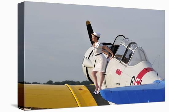 1940's Style Pin-Up Girl Sitting on the Wing of a Vintage T-6 Texan Aircraft-null-Stretched Canvas