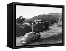 1950s AUSTIN CAR DRIVING UP THE HOLLYWOOD HILLS WITH HOLLYWOOD SIGN IN DISTANCE LOS ANGELES CA USA-Panoramic Images-Framed Stretched Canvas