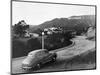 1950s AUSTIN CAR DRIVING UP THE HOLLYWOOD HILLS WITH HOLLYWOOD SIGN IN DISTANCE LOS ANGELES CA USA-Panoramic Images-Mounted Photographic Print