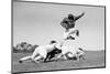 1960s FOOTBALL PLAYER JUMPING OVER BLOCKED PLAYERS-H. Armstrong Roberts-Mounted Photographic Print