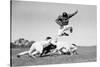 1960s FOOTBALL PLAYER JUMPING OVER BLOCKED PLAYERS-H. Armstrong Roberts-Stretched Canvas