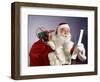 1960s SANTA CLAUS READING THE LIST OF NAUGHTY & NICE SMILING CARRY BAG OF TOYS-Panoramic Images-Framed Photographic Print