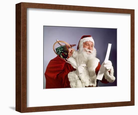 1960s SANTA CLAUS READING THE LIST OF NAUGHTY & NICE SMILING CARRY BAG OF TOYS-Panoramic Images-Framed Photographic Print