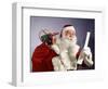 1960s SANTA CLAUS READING THE LIST OF NAUGHTY & NICE SMILING CARRY BAG OF TOYS-Panoramic Images-Framed Photographic Print