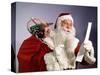 1960s SANTA CLAUS READING THE LIST OF NAUGHTY & NICE SMILING CARRY BAG OF TOYS-Panoramic Images-Stretched Canvas