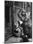 3 Year Old Child Playing with Doll on Window Sill of Apartment-Stan Wayman-Mounted Photographic Print