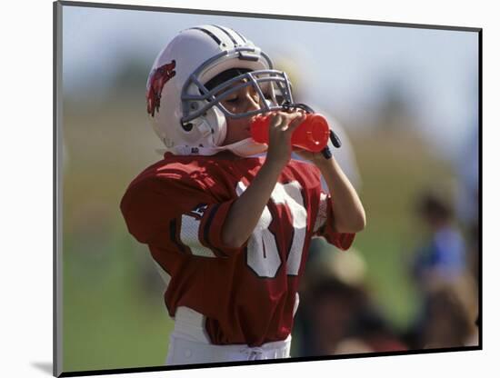 8 Year Old Boy Taking a Drink During a Football Game-null-Mounted Photographic Print