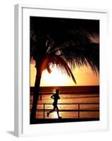 A Afternoon Runner Passes Under a Palm Tree as the Sun Sets Behind-null-Framed Premium Photographic Print