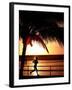 A Afternoon Runner Passes Under a Palm Tree as the Sun Sets Behind-null-Framed Premium Photographic Print