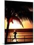 A Afternoon Runner Passes Under a Palm Tree as the Sun Sets Behind-null-Mounted Premium Photographic Print