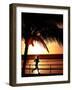 A Afternoon Runner Passes Under a Palm Tree as the Sun Sets Behind-null-Framed Photographic Print