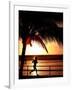 A Afternoon Runner Passes Under a Palm Tree as the Sun Sets Behind-null-Framed Photographic Print