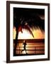 A Afternoon Runner Passes Under a Palm Tree as the Sun Sets Behind-null-Framed Photographic Print