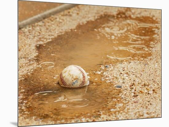 A Baseball Sits in a Puddle-null-Mounted Photographic Print