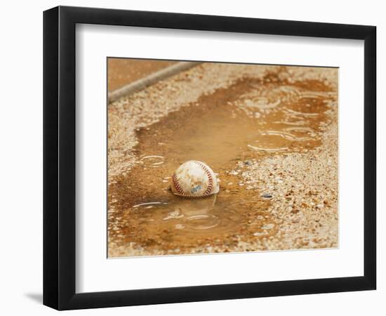 A Baseball Sits in a Puddle-null-Framed Photographic Print