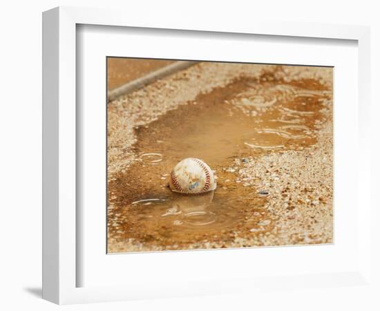 A Baseball Sits in a Puddle-null-Framed Photographic Print