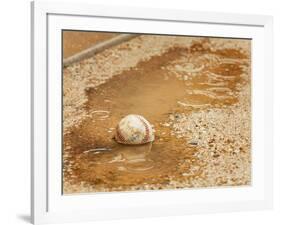 A Baseball Sits in a Puddle-null-Framed Photographic Print