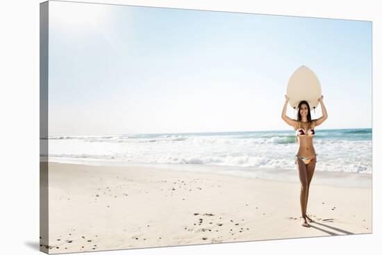 A Beautiful Surfer Girl at the Beach Holding up Her Surfboard-iko-Stretched Canvas