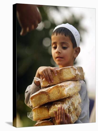 A Boy Carries Rusk as He Assists Others to Send a Consignment of Relief Supplies to Uri-null-Stretched Canvas