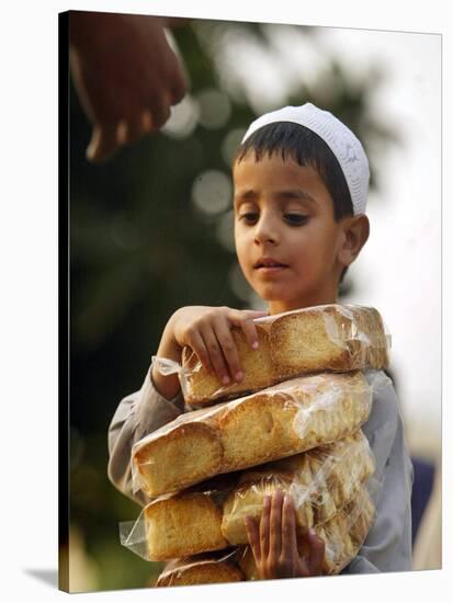 A Boy Carries Rusk as He Assists Others to Send a Consignment of Relief Supplies to Uri-null-Stretched Canvas