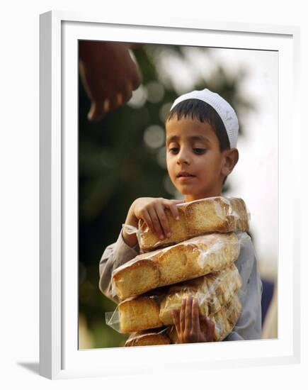 A Boy Carries Rusk as He Assists Others to Send a Consignment of Relief Supplies to Uri-null-Framed Premium Photographic Print