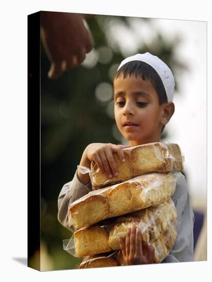 A Boy Carries Rusk as He Assists Others to Send a Consignment of Relief Supplies to Uri-null-Stretched Canvas