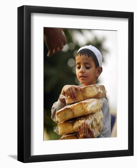 A Boy Carries Rusk as He Assists Others to Send a Consignment of Relief Supplies to Uri-null-Framed Photographic Print