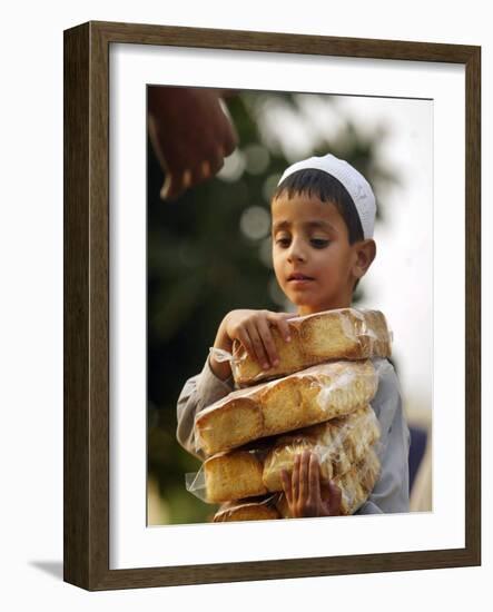 A Boy Carries Rusk as He Assists Others to Send a Consignment of Relief Supplies to Uri-null-Framed Photographic Print
