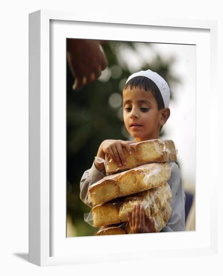 A Boy Carries Rusk as He Assists Others to Send a Consignment of Relief Supplies to Uri-null-Framed Photographic Print